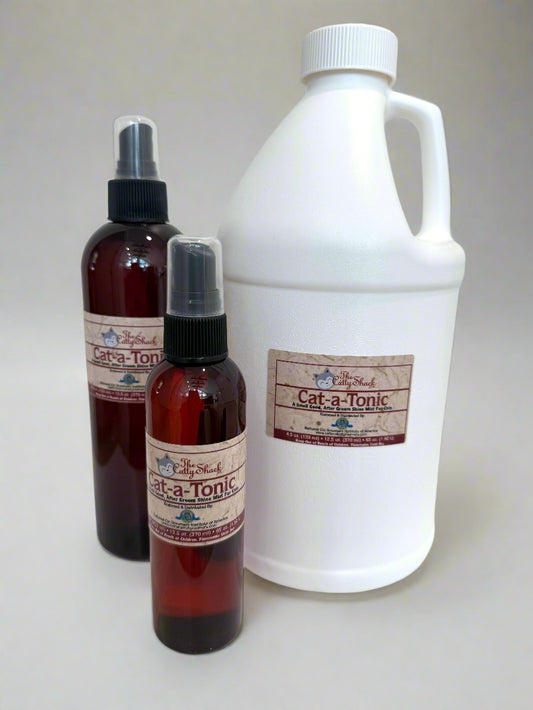 Three bottles of Cat-a-Tonic on a white surface with a light gray background